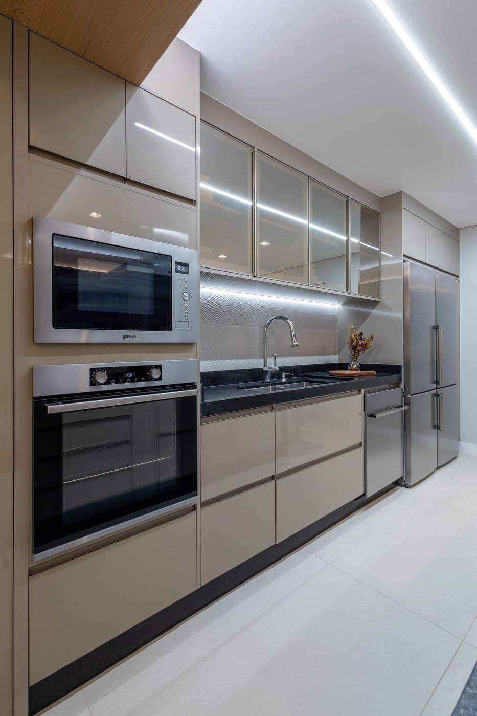 Cozinha com armários claros, micro-ondas e forno embutidos